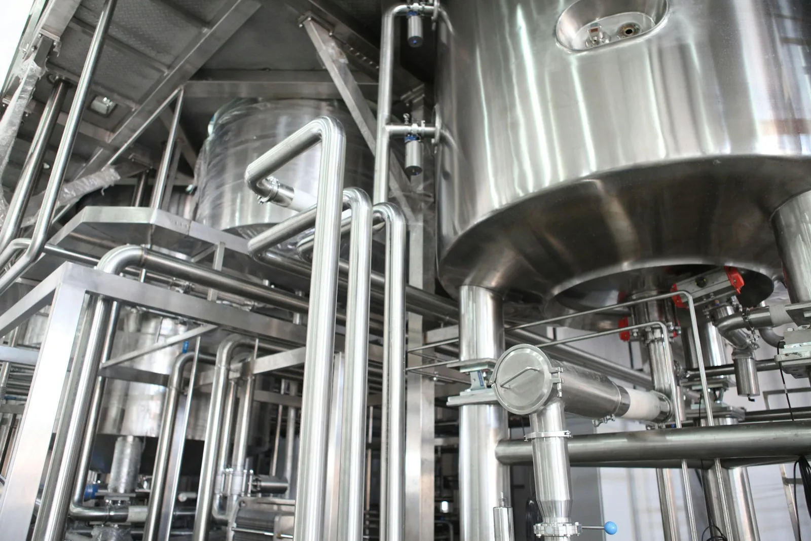 Depósitos y tuberías de acero inoxidable en la sala de proceso de una industria alimentaria